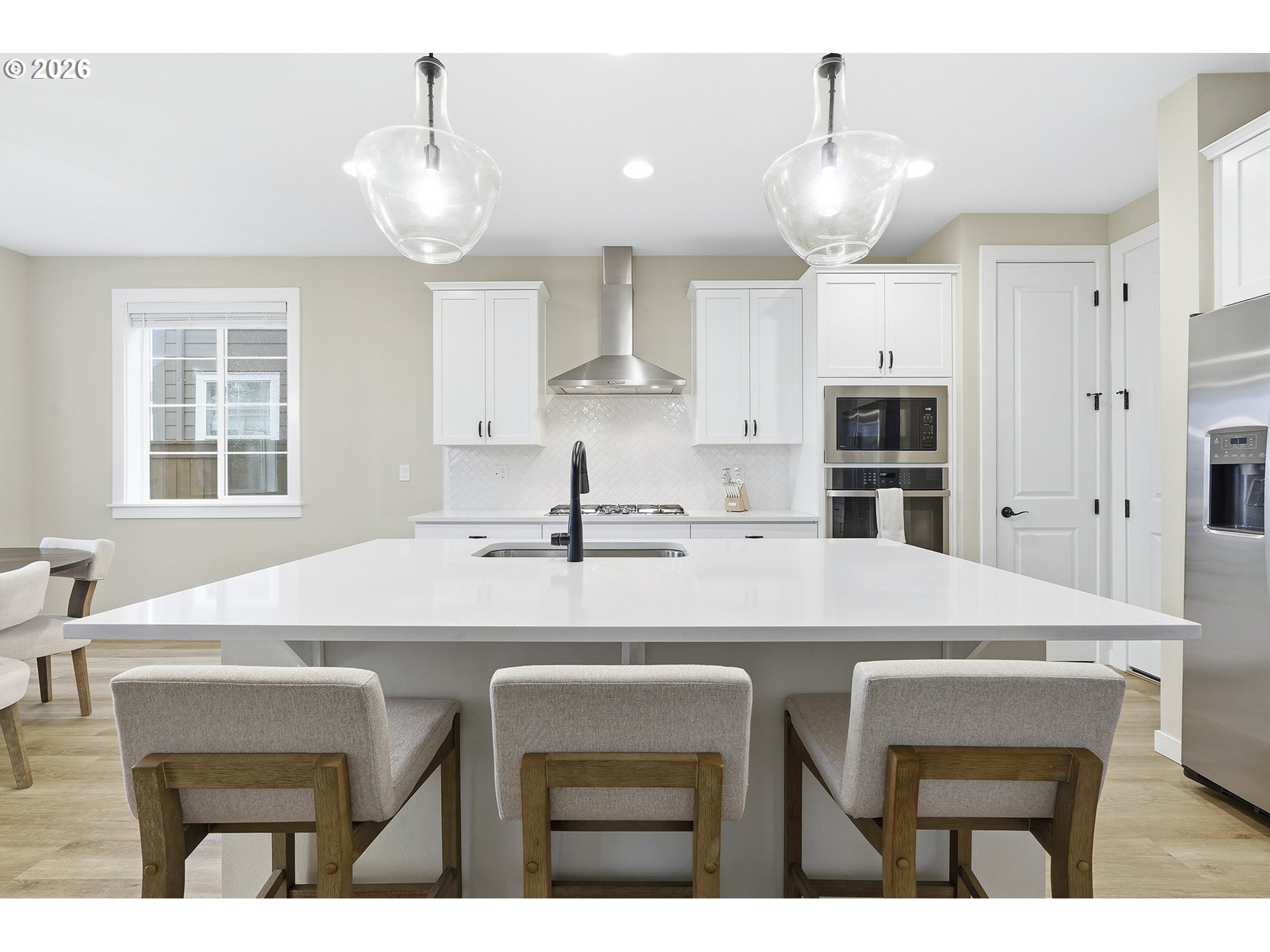 6724 Southwest Lupine Way Wilsonville, OR 97070 - Photo 15 of 45 a kitchen with stainless steel appliances kitchen island a table chairs and a refrigerator
