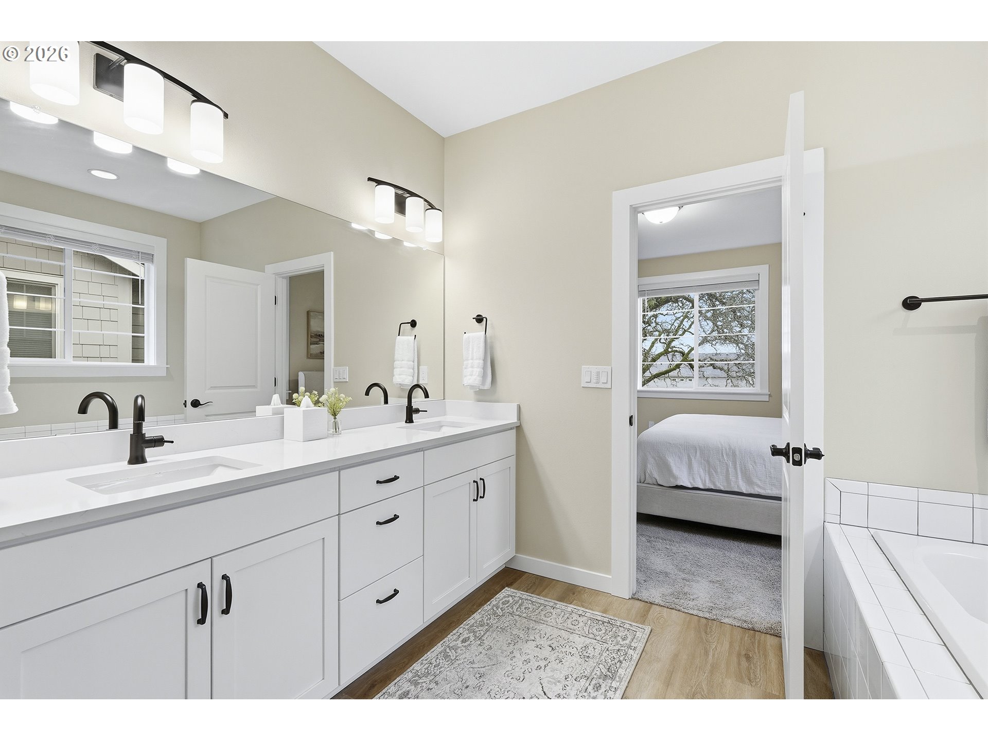 6724 Southwest Lupine Way Wilsonville, OR 97070 - Photo 34 of 45 a en suite bathroom with a double vanity sink a mirror and a bathtub