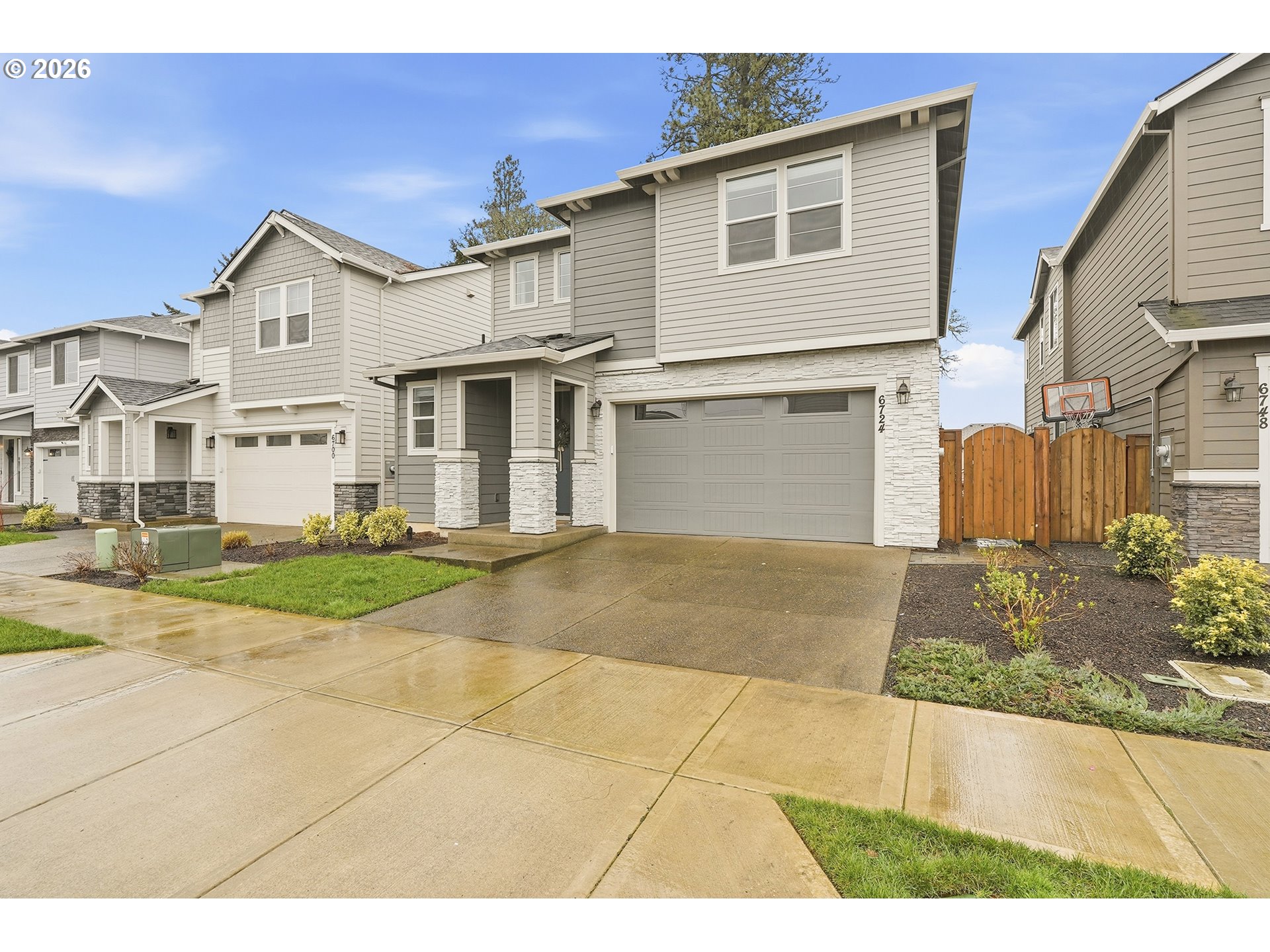6724 Southwest Lupine Way Wilsonville, OR 97070 - Photo 4 of 45 a view of a white house with a yard and large tree