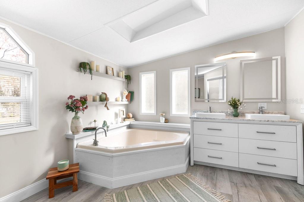 18137 Hollister Road Orlando, FL 32820 - Photo 13 of 27 a bathroom with a tub sink and mirror