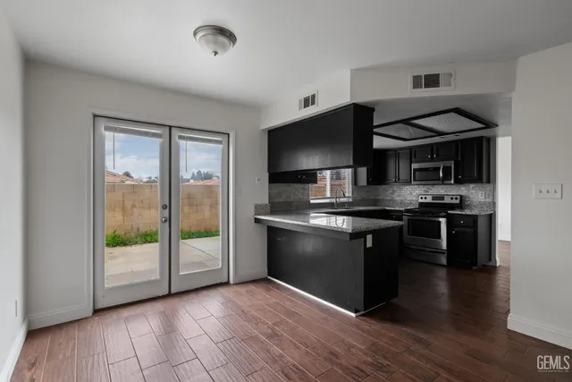 a kitchen with stainless steel appliances granite countertop a stove and a refrigerator