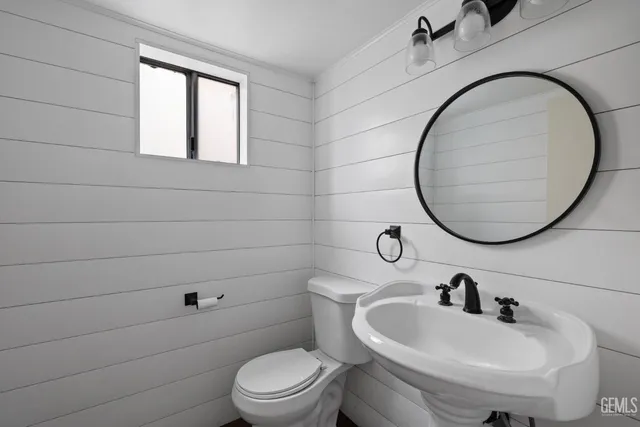 a bathroom with a sink a toilet and a mirror