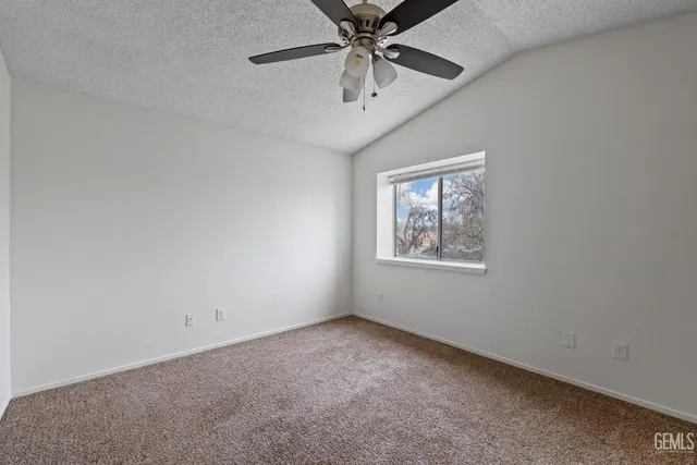 an empty room with a window and a ceiling fan