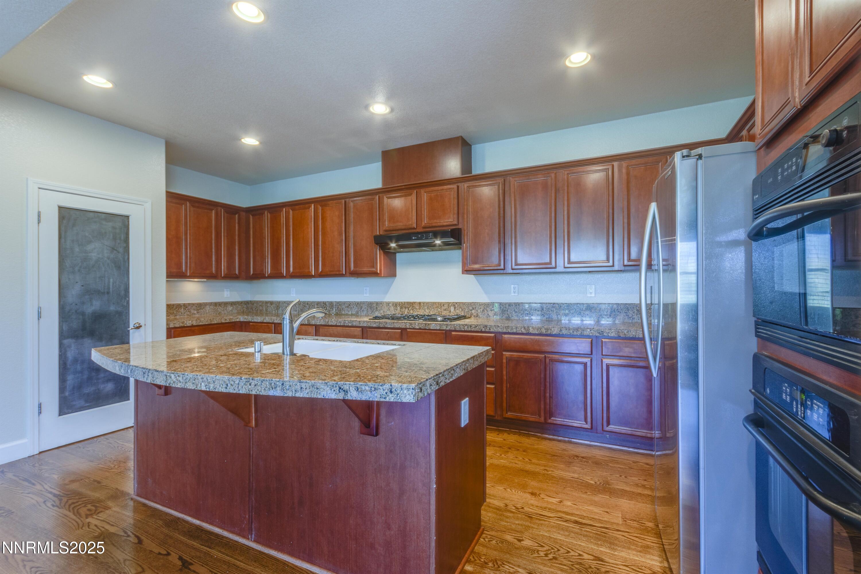 1798 Evening Rock Court Reno, NV 89523 - Photo 11 of 27 a kitchen with kitchen island granite countertop a sink and wooden cabinets