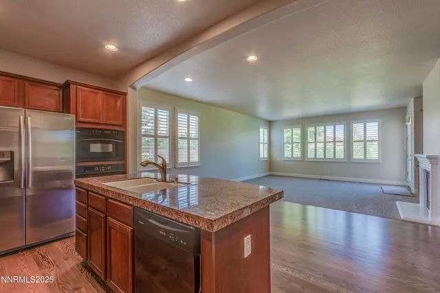 a kitchen with stainless steel appliances granite countertop a sink a stove and a refrigerator