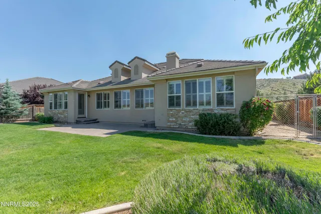 a view of a house with a yard and potted plants