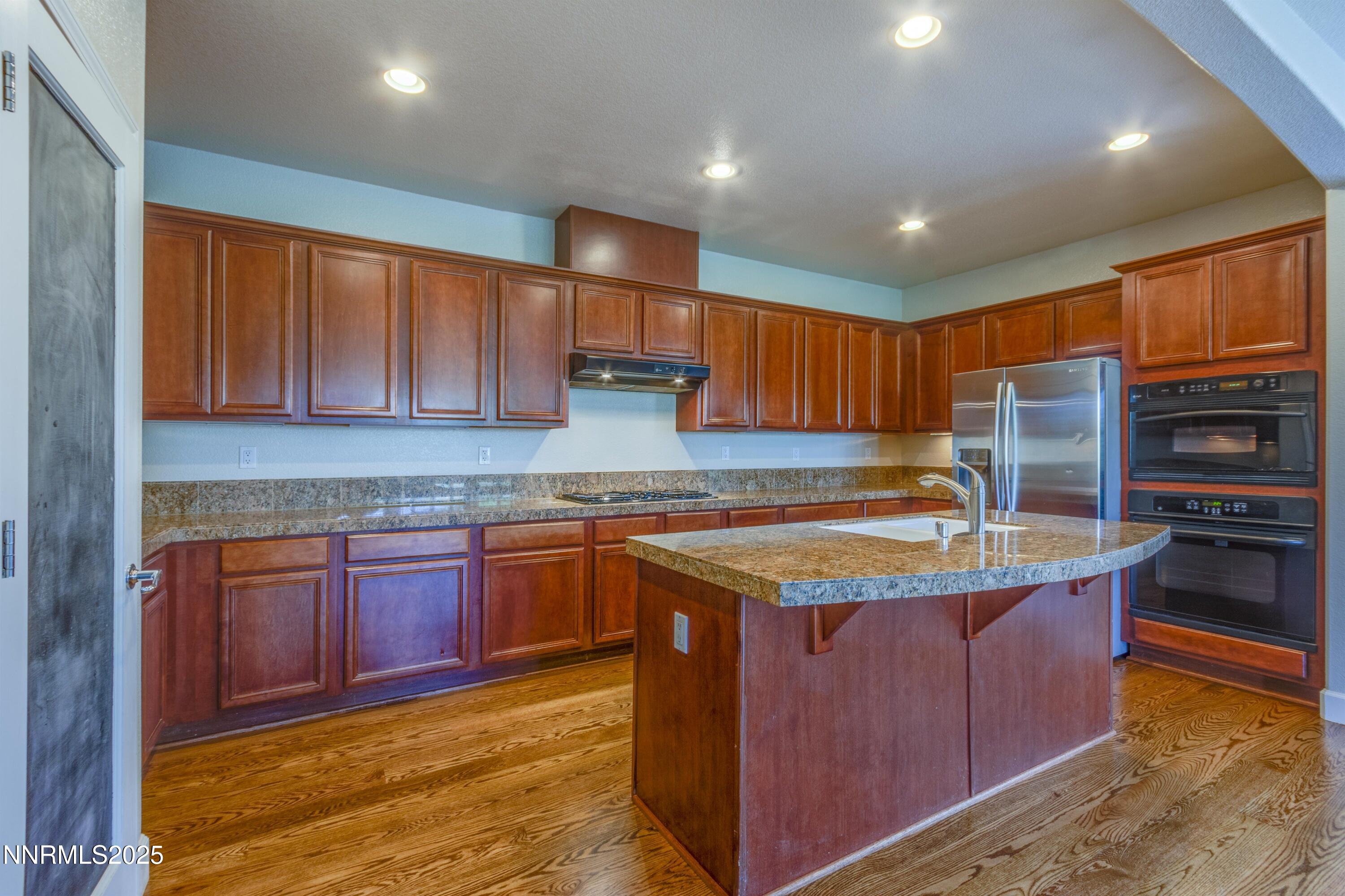 1798 Evening Rock Court Reno, NV 89523 - Photo 10 of 27 a kitchen with stainless steel appliances granite countertop wooden cabinets a stove and a sink