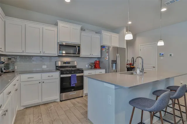 a kitchen with cabinets a sink and stainless steel appliances