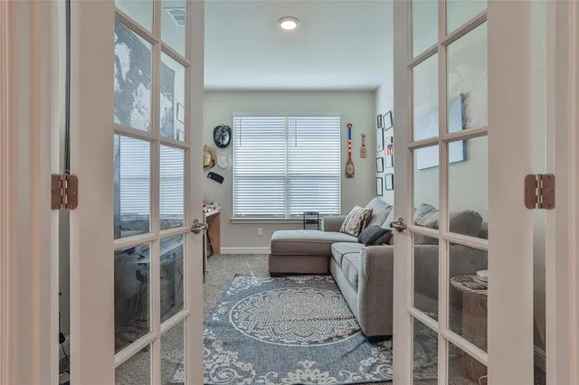a living room with furniture a large window and a wooden floor