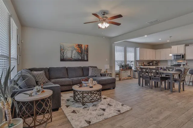 a living room with furniture kitchen and a chandelier