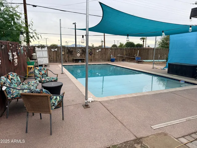 a view of a swimming pool with a chair and tables in the patio
