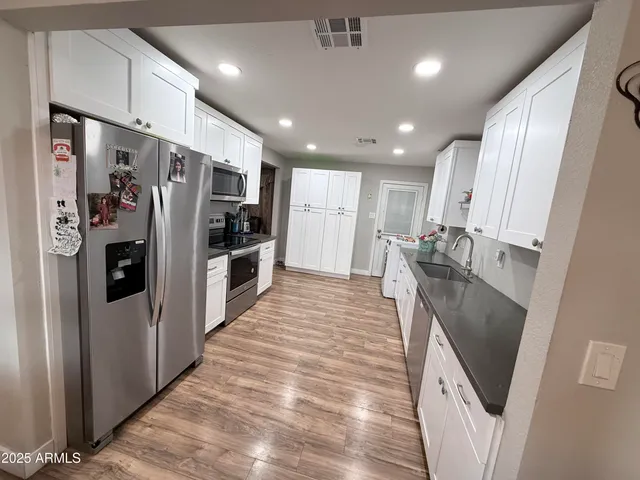 a kitchen with stainless steel appliances granite countertop a refrigerator and a sink