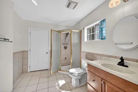a bathroom with a granite countertop sink a mirror and a bathtub