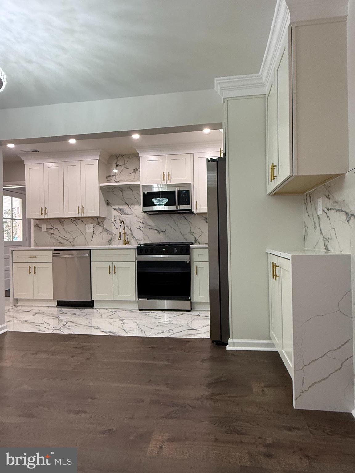 1203 Riggs Court Woodbridge, VA 22191 - Photo 20 of 39 a kitchen with stainless steel appliances granite countertop a stove top oven a sink dishwasher and a refrigerator with wooden floor