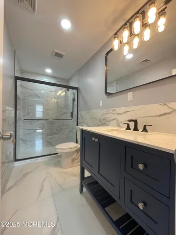 a bathroom with a sink a toilet and shower