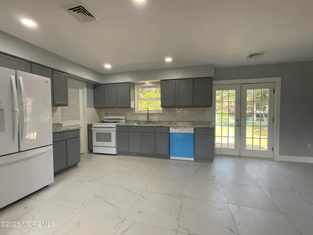 a kitchen with granite countertop stainless steel appliances and white cabinets