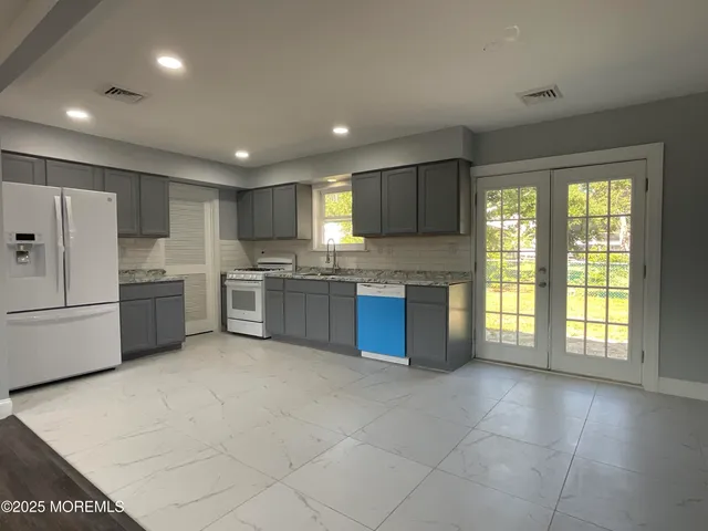 a kitchen with a refrigerator and a stove top oven