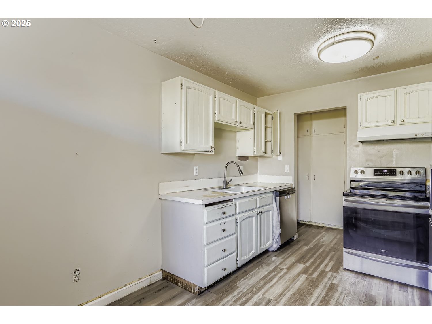 6524 Southeast 86th Avenue Portland, OR 97266 - Photo 11 of 30 a kitchen with stainless steel appliances granite countertop a stove a sink and white cabinets