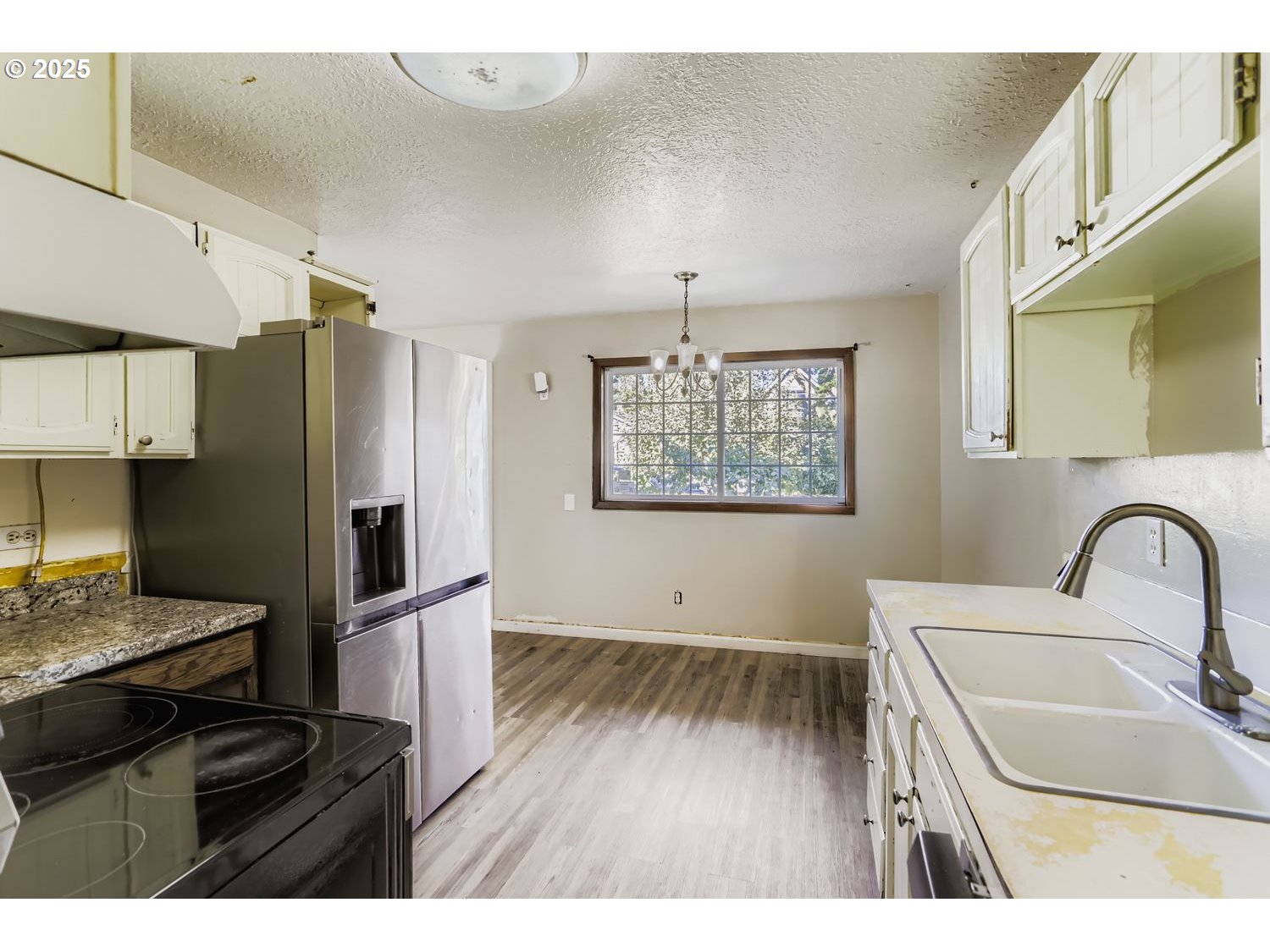 6524 Southeast 86th Avenue Portland, OR 97266 - Photo 14 of 30 a kitchen with kitchen island a refrigerator wooden floor a sink and a stove