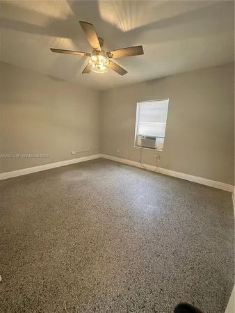 an empty room with a chandelier fan