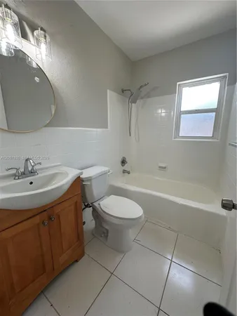 a bathroom with a toilet a sink a mirror and bathtub