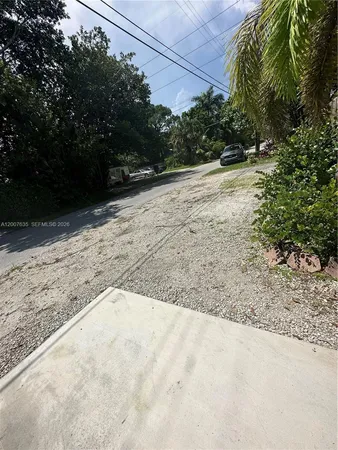 a view of a yard with plants and trees