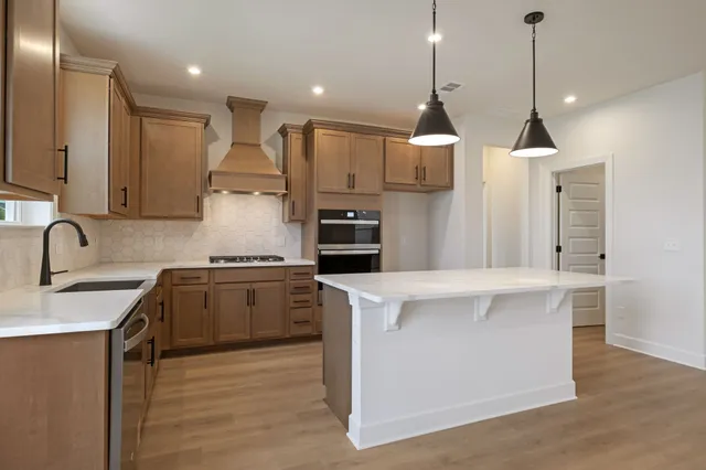 a kitchen with kitchen island a sink stainless steel appliances and cabinets
