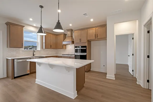 a kitchen with a stove a refrigerator and a sink