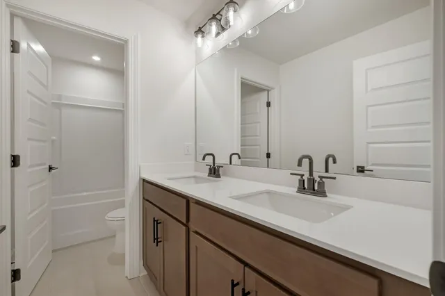 a bathroom with a sink double vanity granite tub and shower