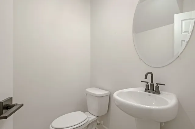 a bathroom with a toilet sink and mirror