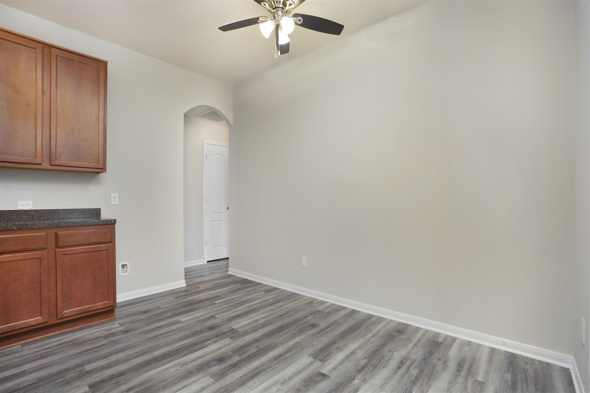 384 Decoster Boulevard Alvin, TX 77511 - Photo 15 of 27 an empty room with wooden floor cabinet and a ceiling fan