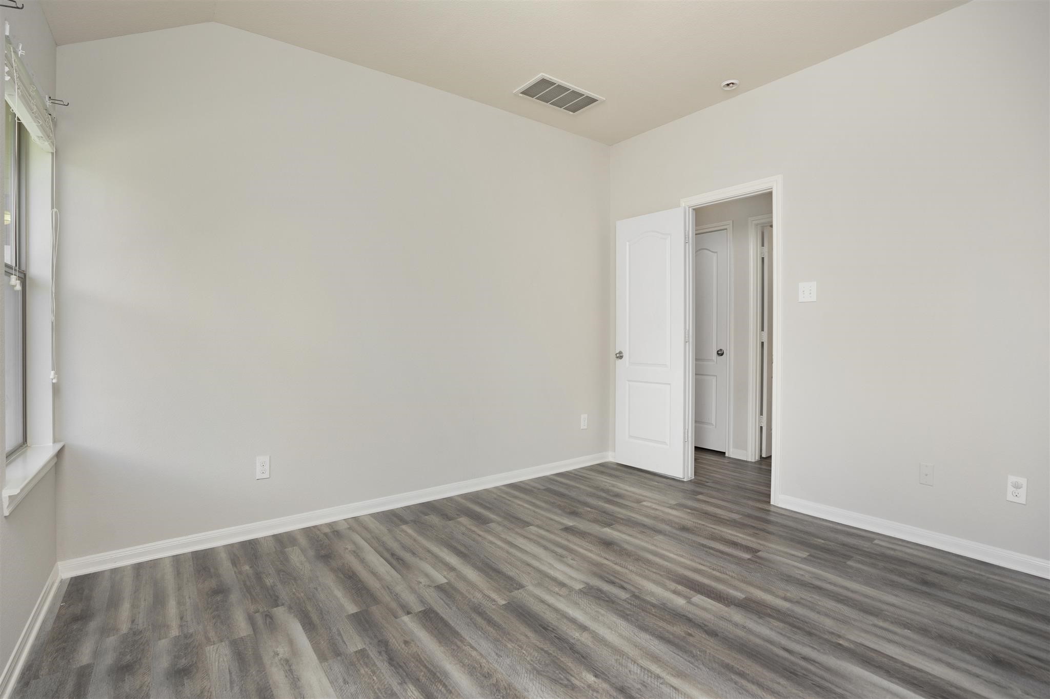 384 Decoster Boulevard Alvin, TX 77511 - Photo 17 of 27 a view of an empty room with wooden floor and a window