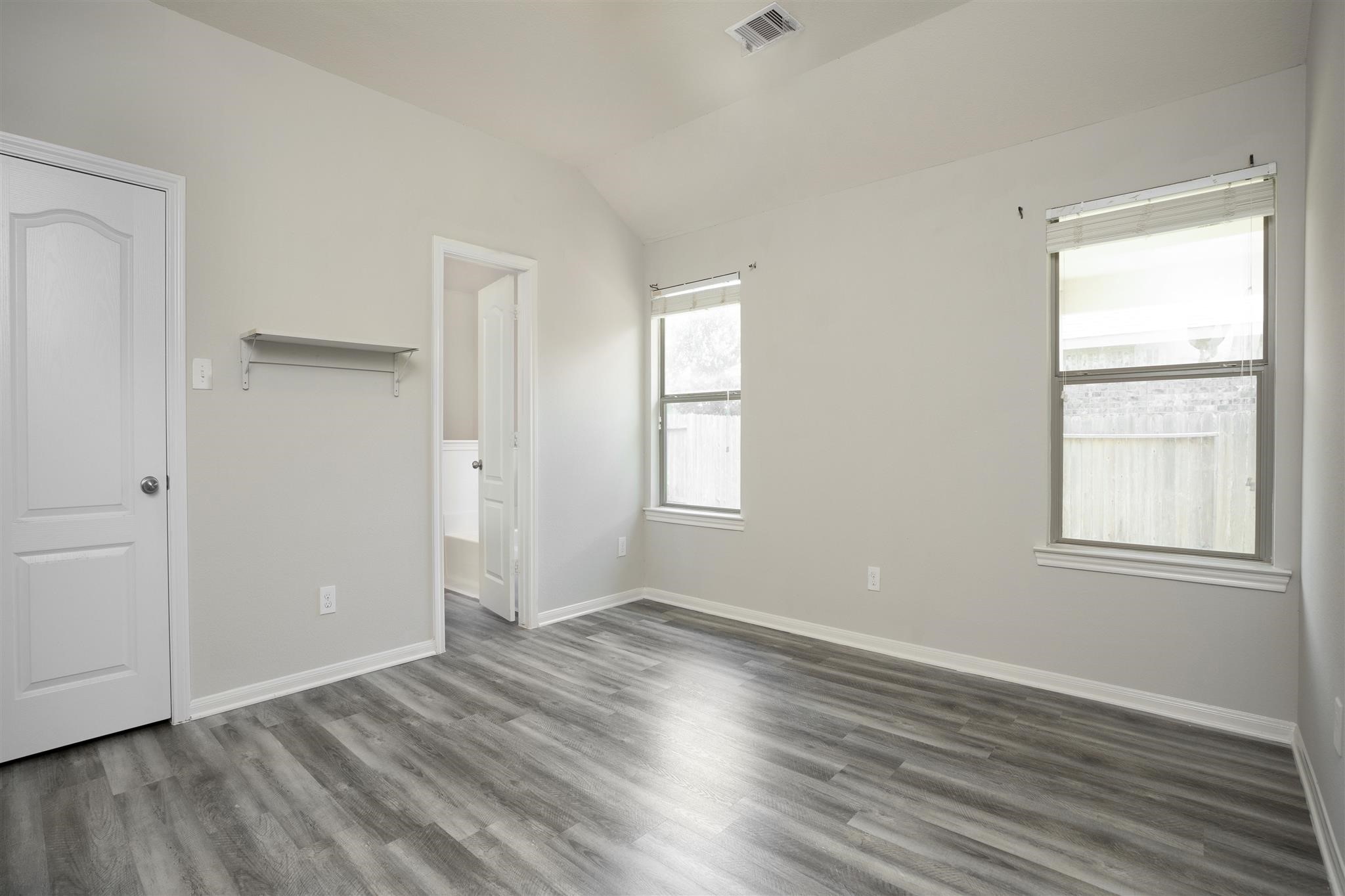 384 Decoster Boulevard Alvin, TX 77511 - Photo 19 of 27 an empty room with wooden floor and windows