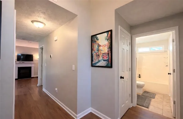 a view of a hallway with bathroom and wooden floor