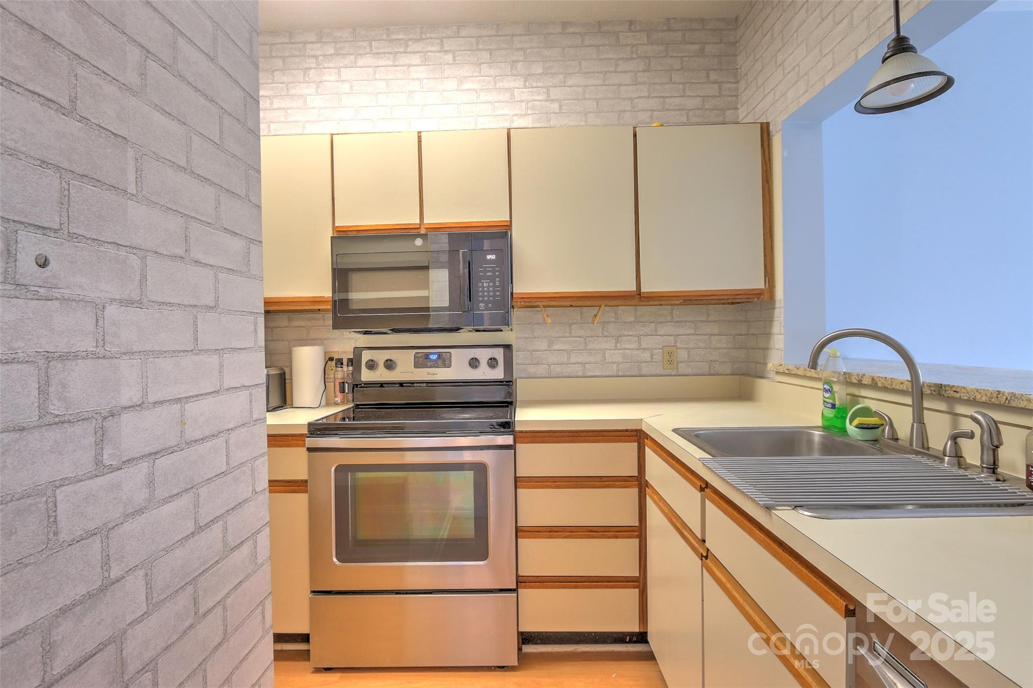 5 Gumtree Road, Unit D3 Hilton Head Island, SC 29926 - Photo 2 of 17 a kitchen with granite countertop a stove a sink and a microwave