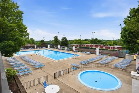 a view of swimming pool with outdoor seating and plants in the background