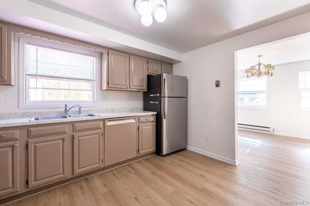 a kitchen with a refrigerator sink and cabinets