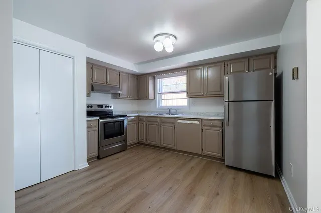 a kitchen with a refrigerator a sink and cabinets