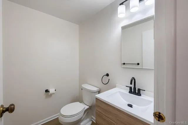 a bathroom with a sink mirror and toilet