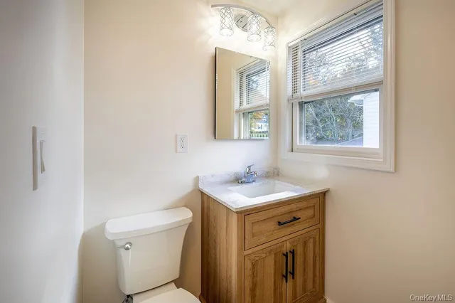 a bathroom with a sink a toilet and a window