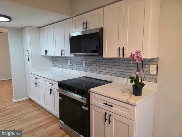 a kitchen with stainless steel appliances granite countertop a sink and a stove