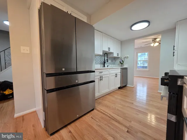 a kitchen with stainless steel appliances granite countertop a refrigerator a stove and a sink