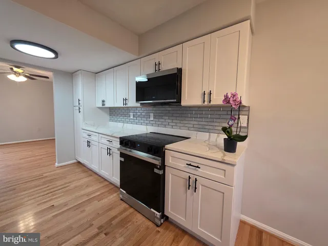 a kitchen with stainless steel appliances granite countertop a sink stove and microwave