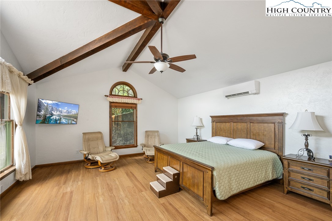 281 Cliffside Lane Seven Devils, NC 28604 - Photo 14 of 29 a bedroom with a bed and a chandelier