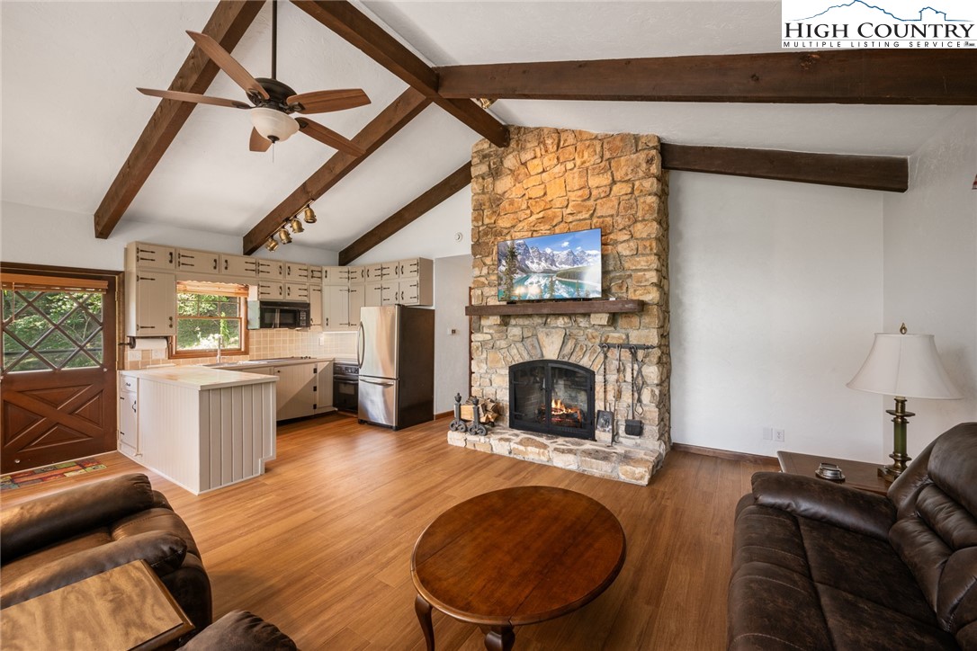 281 Cliffside Lane Seven Devils, NC 28604 - Photo 9 of 29 a living room with furniture a fireplace and a flat screen tv