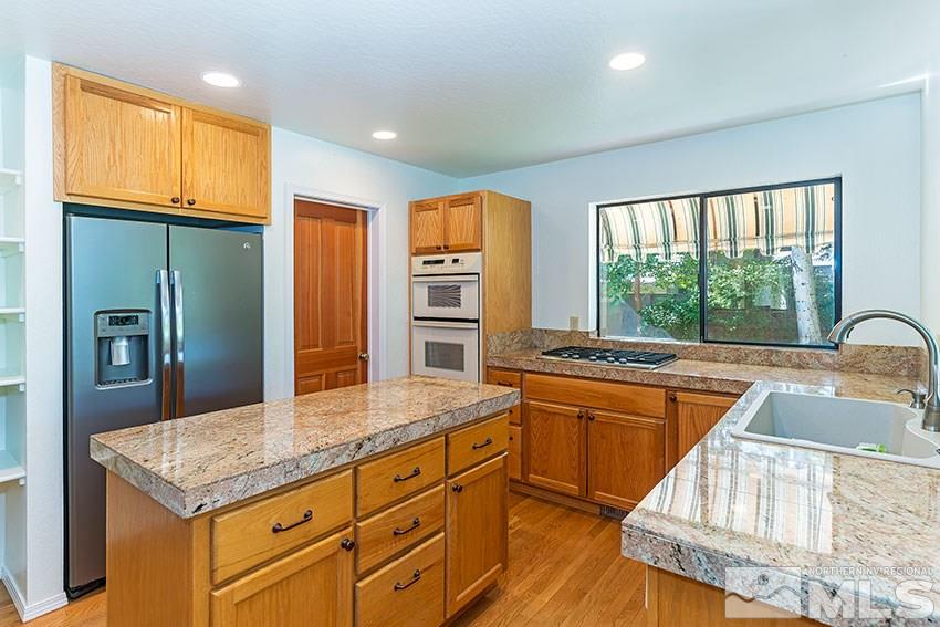 4655 Lakewood Court Reno, NV 89509 - Photo 8 of 21 a kitchen with stainless steel appliances granite countertop a sink and a refrigerator