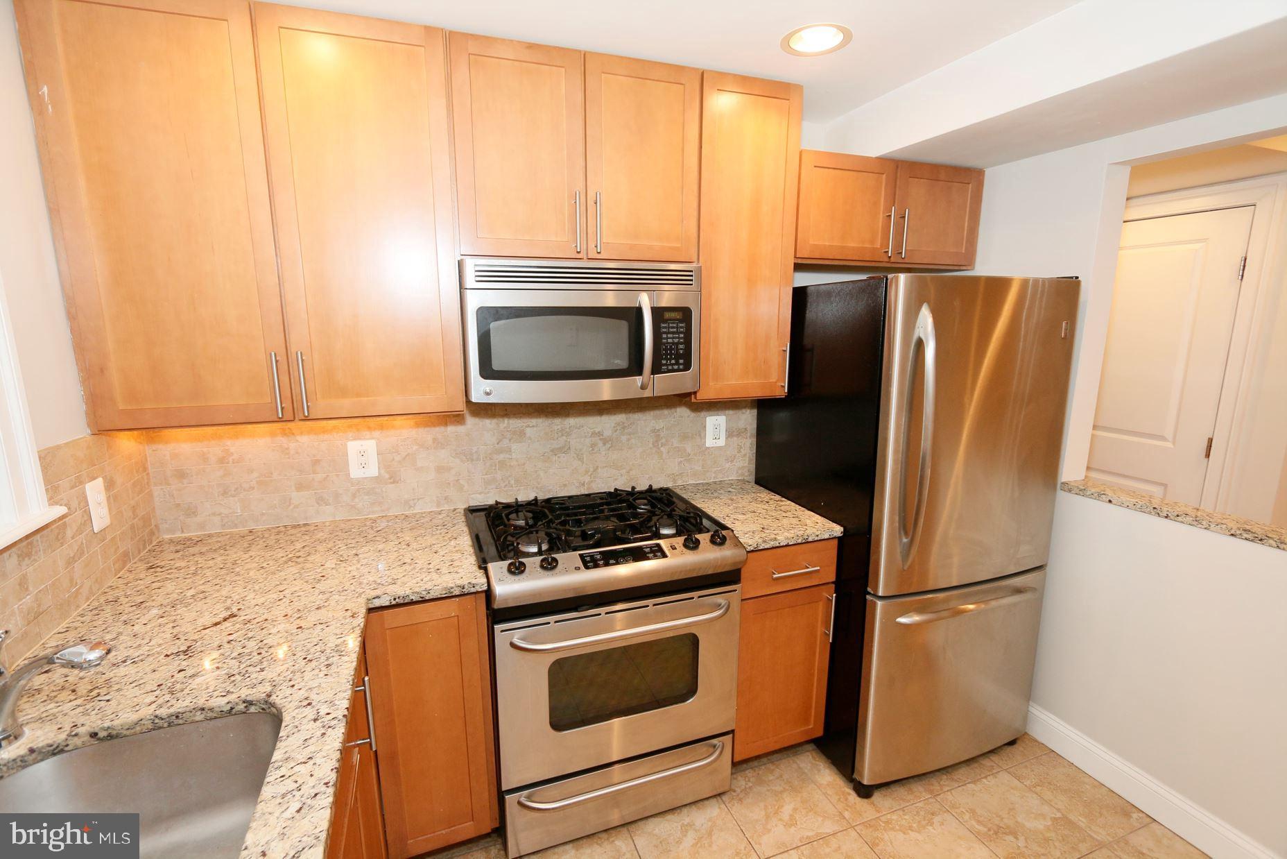 1901 Lincoln Road Northeast, Unit 101 Washington, DC 20002 - Photo 1 of 17 a kitchen with stainless steel appliances granite countertop a refrigerator stove and microwave