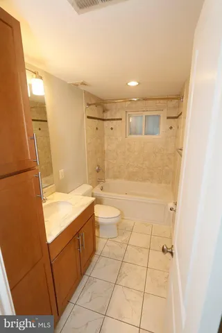 a bathroom with a granite countertop sink a toilet and shower