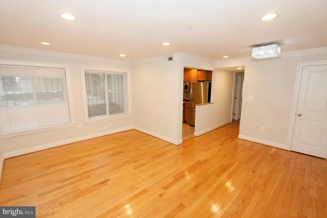 a view of empty room with wooden floor and windows