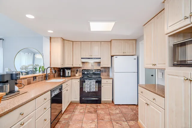 a kitchen with white cabinets and white appliances